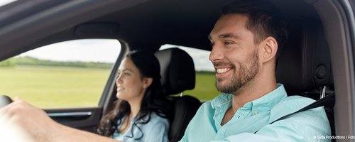 Ein Pärchen sitzt im Auto.
